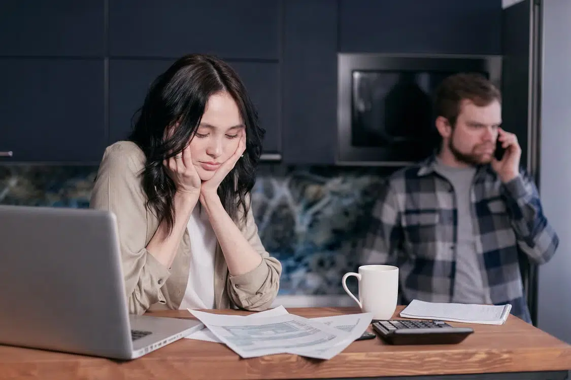 A couple looking at bills seeming distressed.