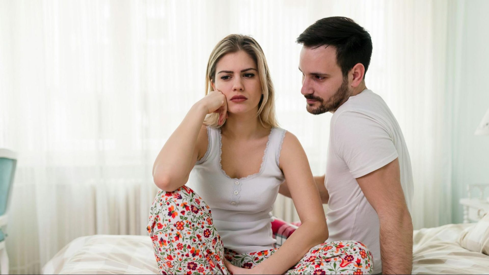A woman appears angry as a man approaches her with an apology.