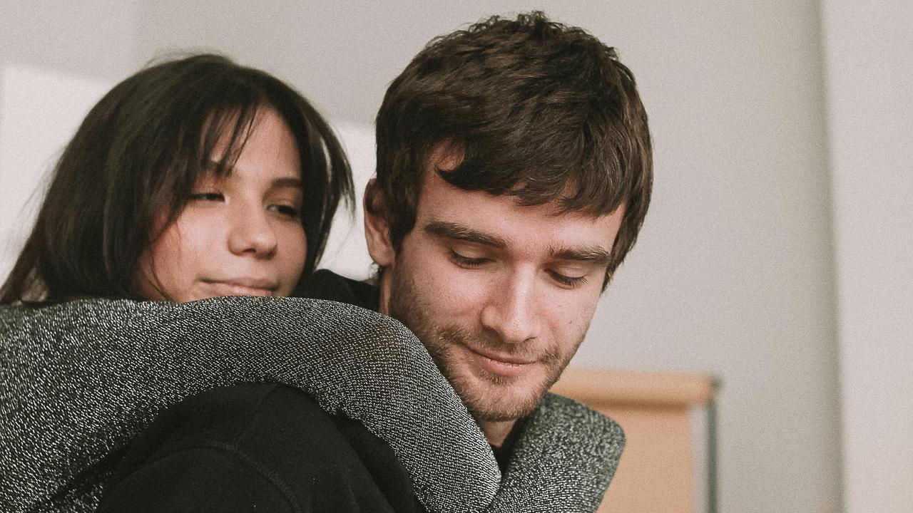 A woman hugging a man from behind.