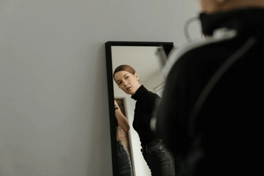 A woman looking at herself in the mirror