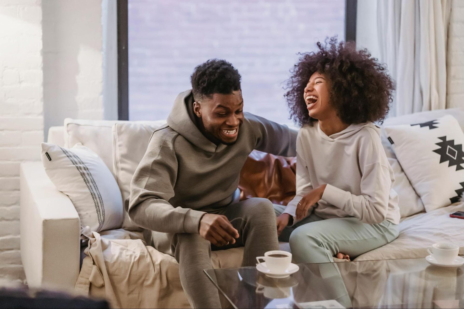 Couple laughing together on a couch