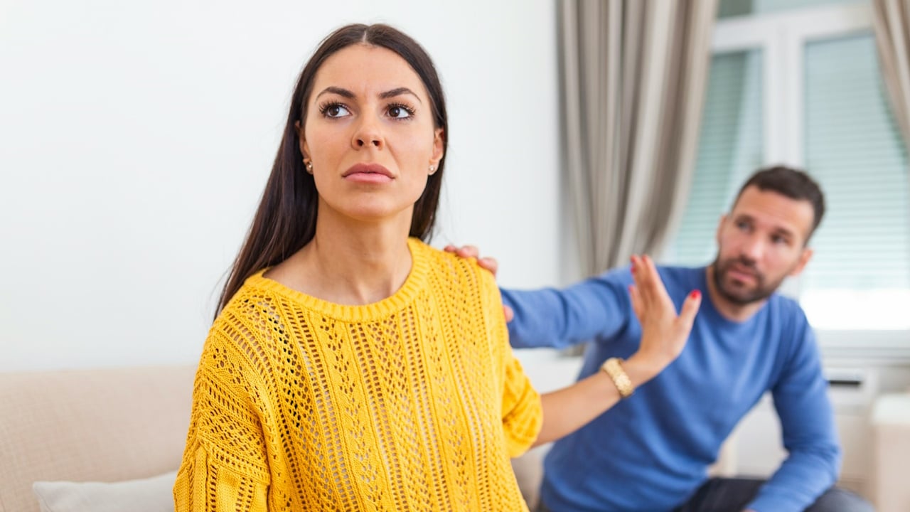 A stressed young man saying sorry after a quarrel to his frustrated wife.