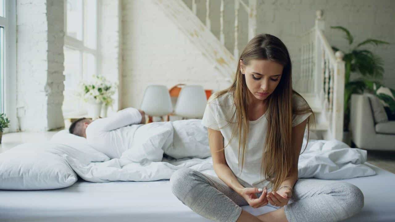 A couple looking sad in the bedroom