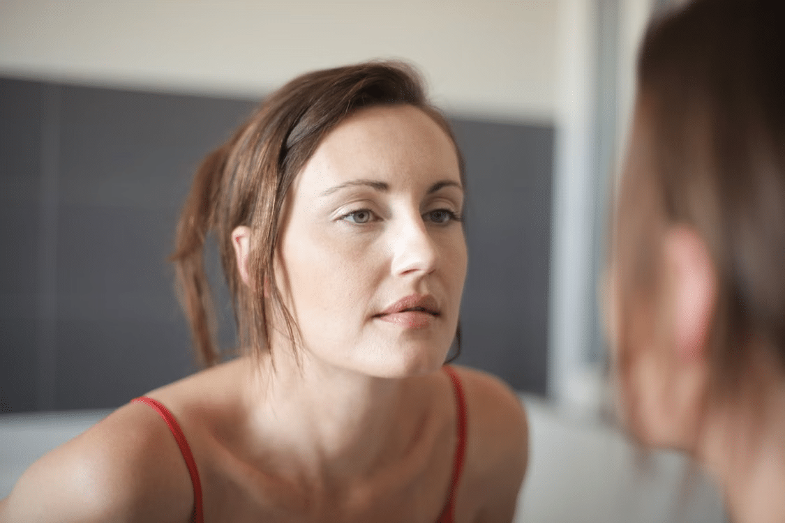 A woman with self-doubt looking at herself questioning her worth in her relationship.