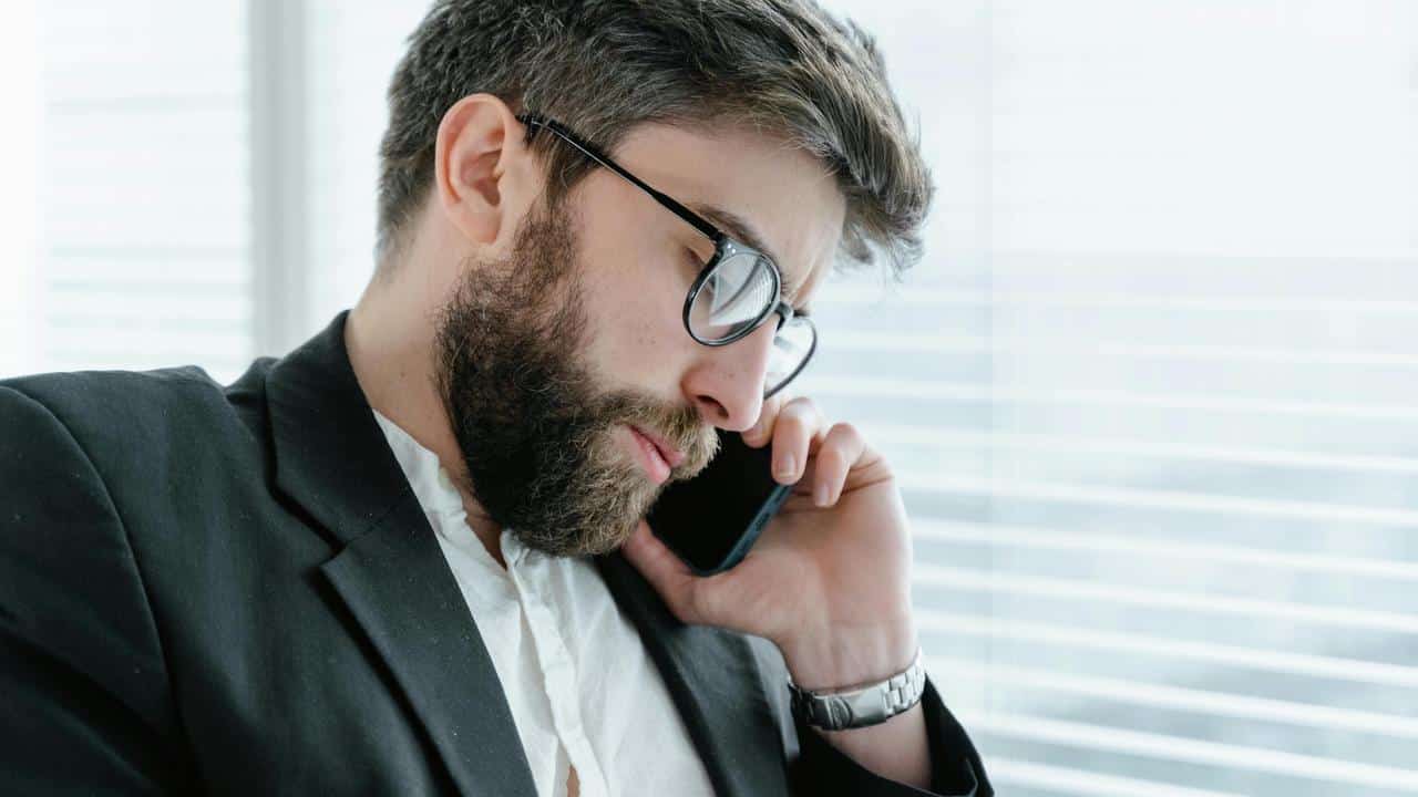 A man in a suit talking on a phone.