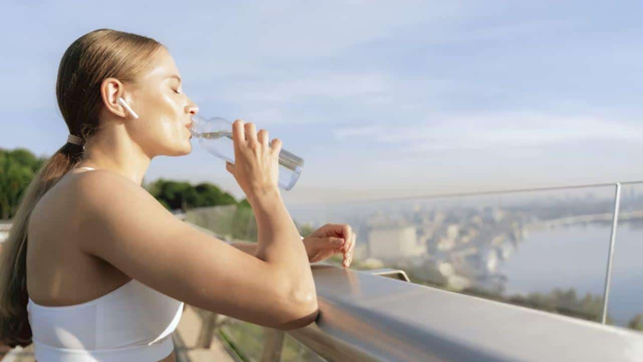 Woman drinking water and taking a deep breath