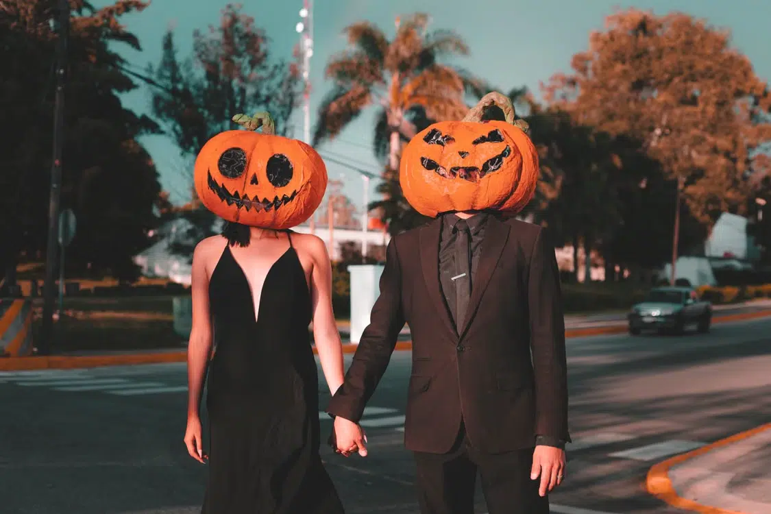 A couple holding hands as they walk down the street.