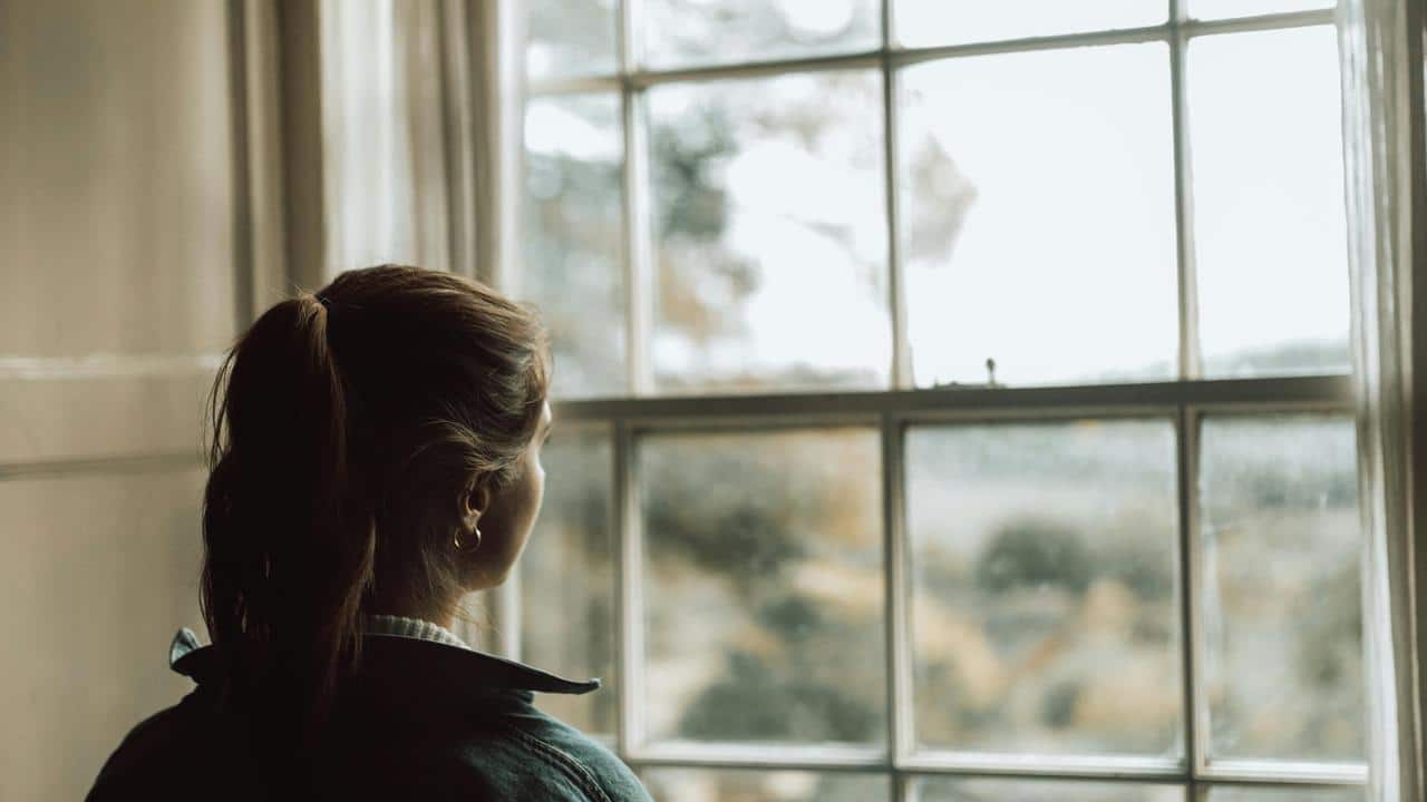 A woman looks out a window.