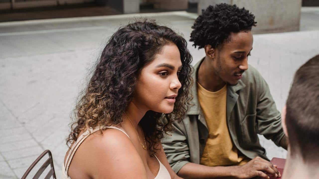 A woman and a man sitting outside having a conversation.