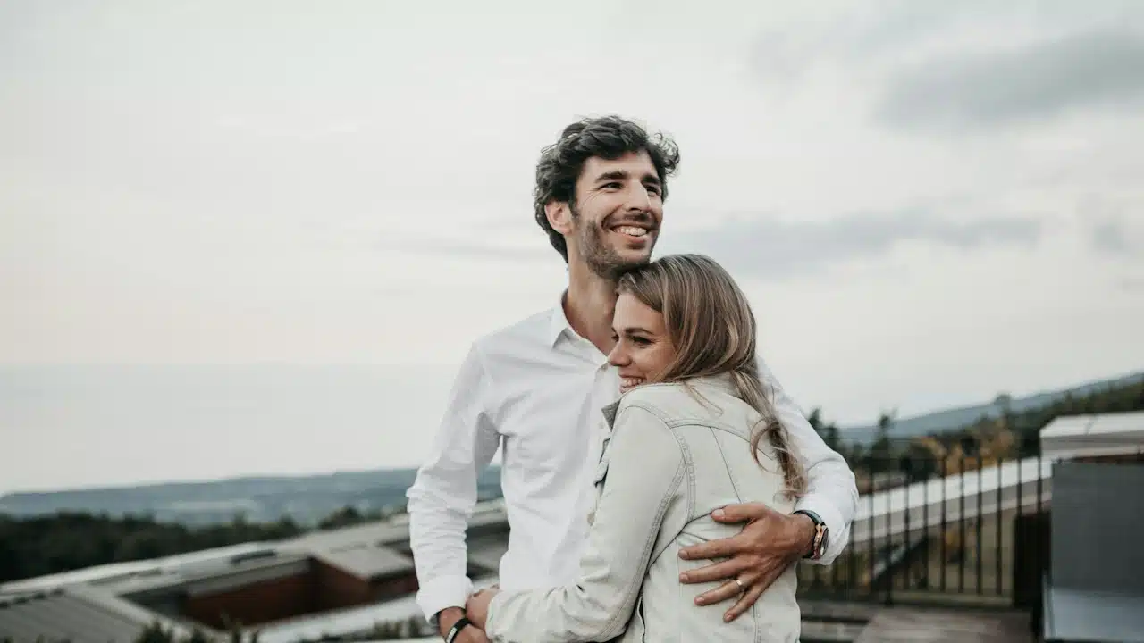 A man and a woman hugging each other.
