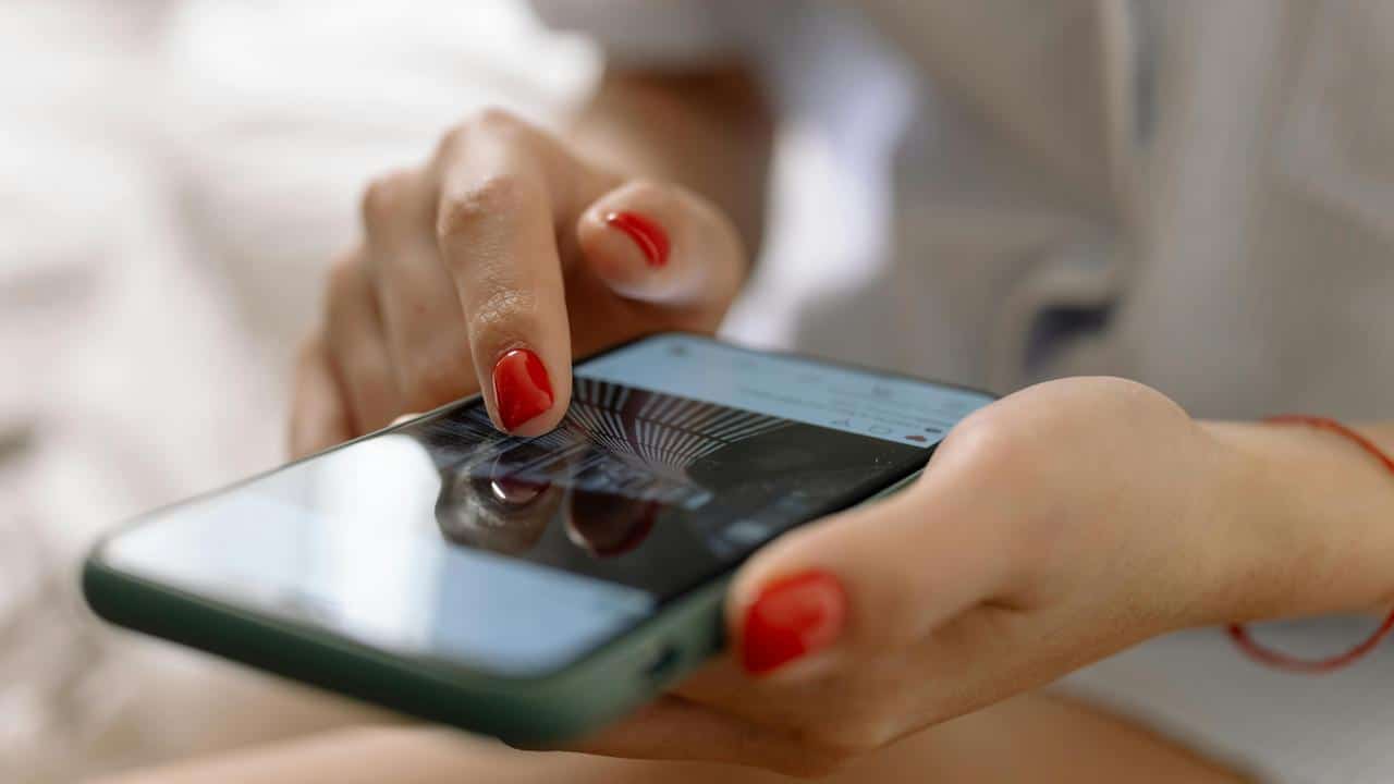 A close-up of a hand using a smartphone.