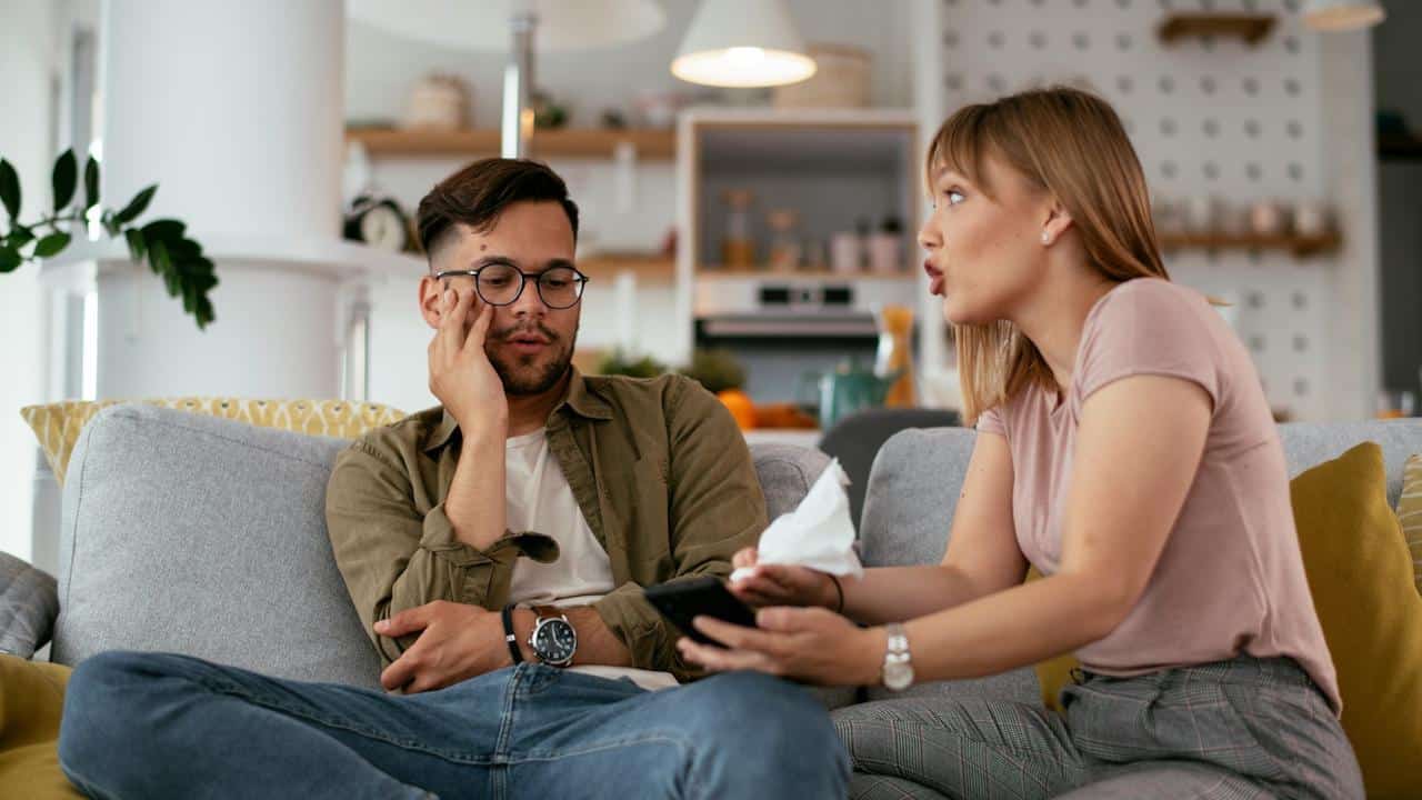 A man pretending to listen to a woman while she talks excitedly.