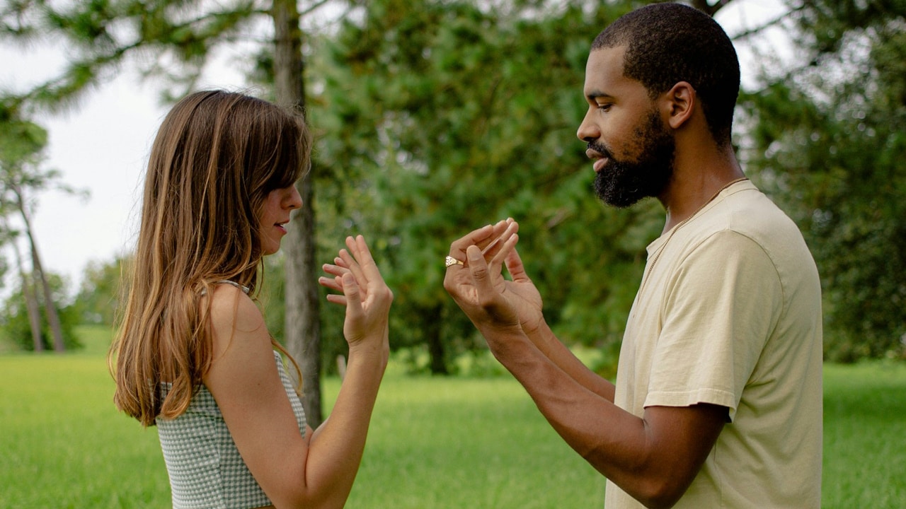 A man and a woman standing in a field.