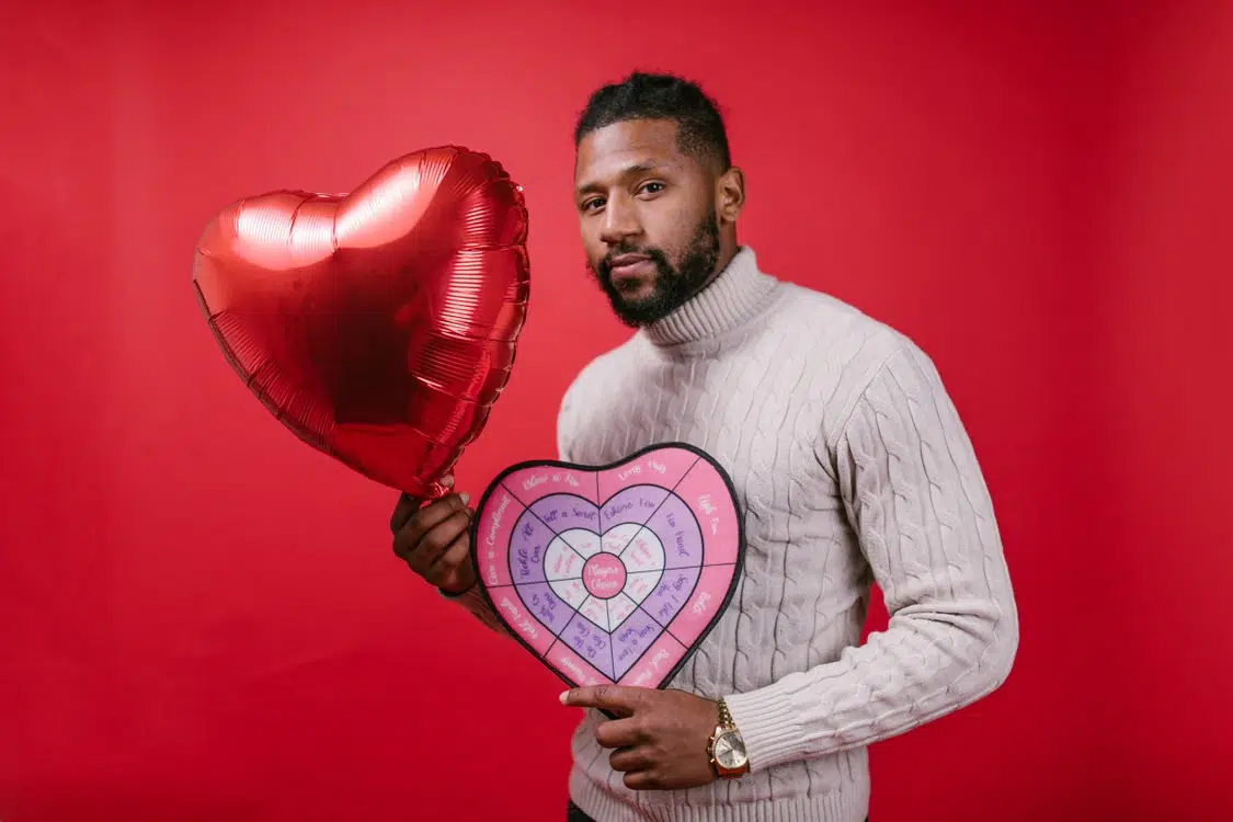 A man holding a heart shaped balloon.