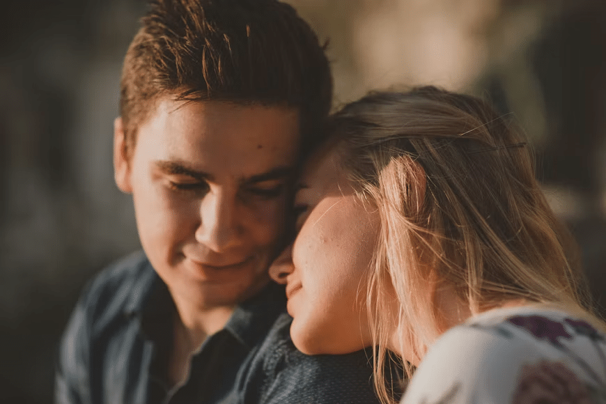 A woman fondly leaning onto a mans shoulder.