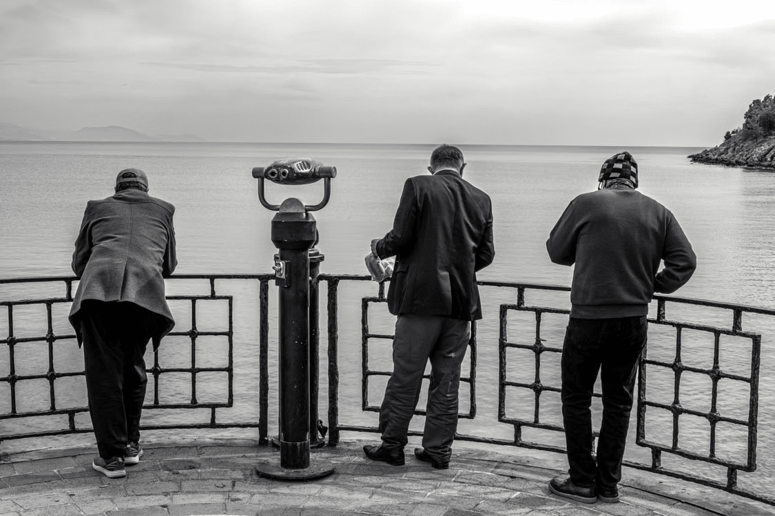 Three men observing the sea.