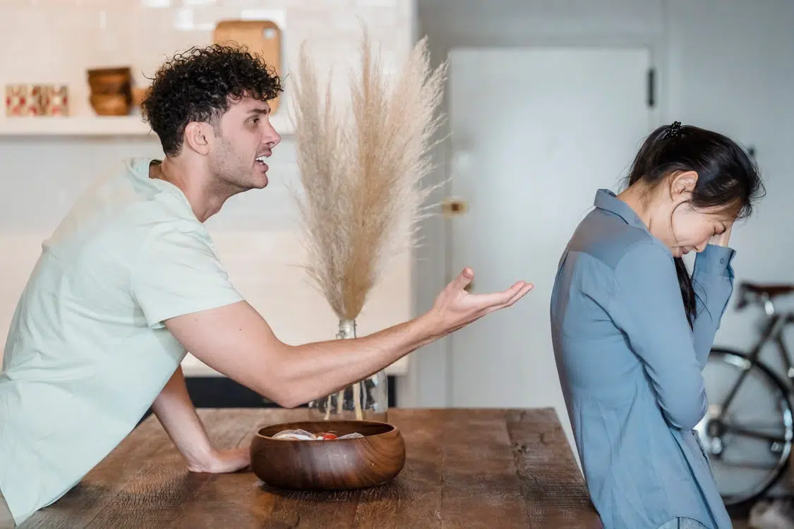 A woman and man arguing as she turns her back to him