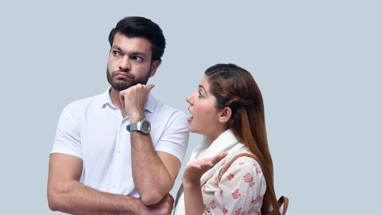 A bearded man ignoring a woman nagging him.