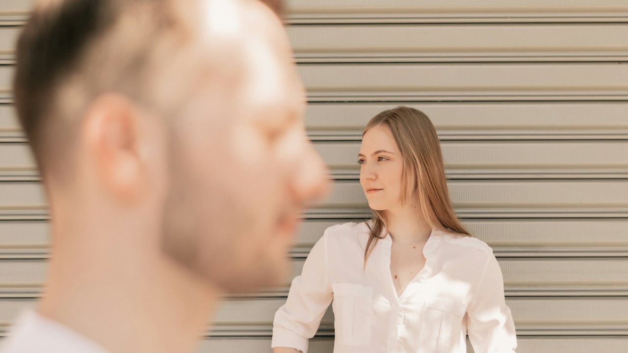 A man and a woman standing in front of a garage door.