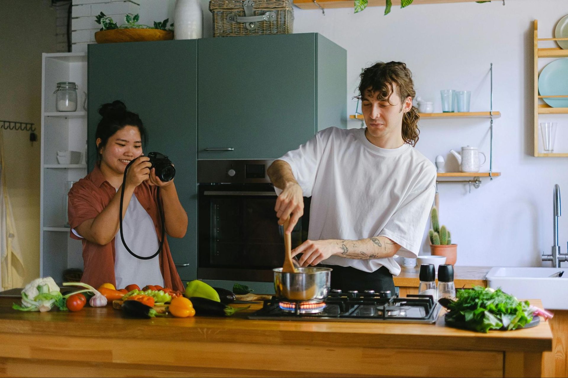 Woman taking picture of a man cooking
