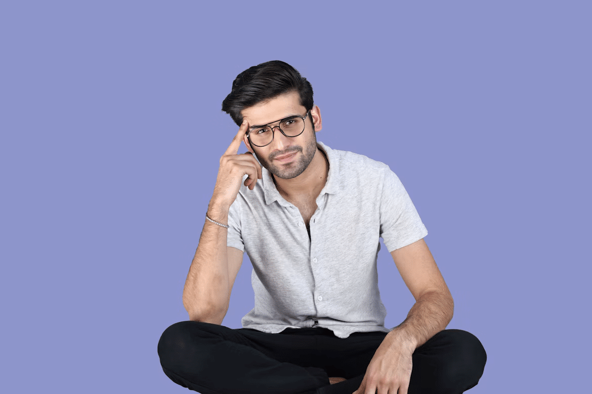 A young man wearing glasses seems bored.