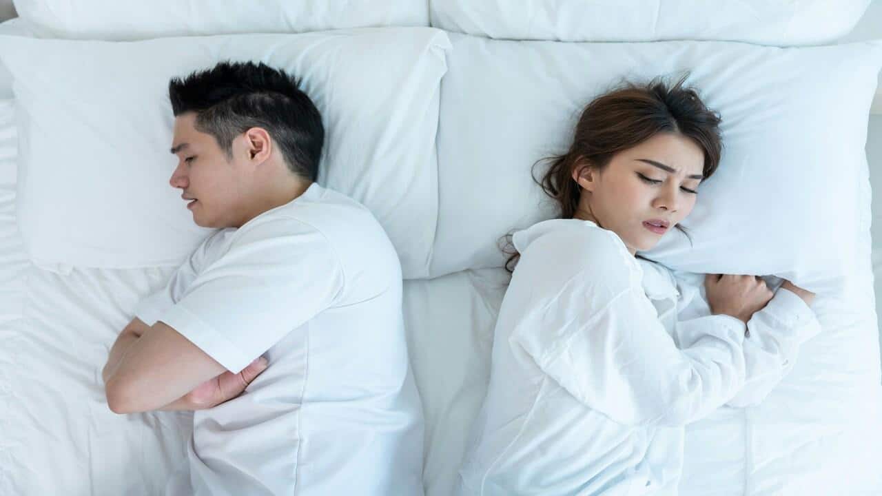 A couple looking sad in bed