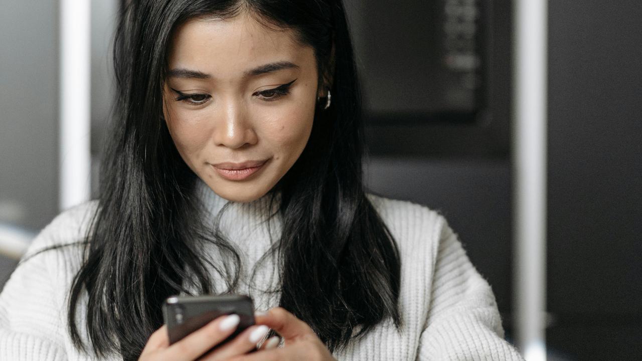 A woman looking at her phone indoors.