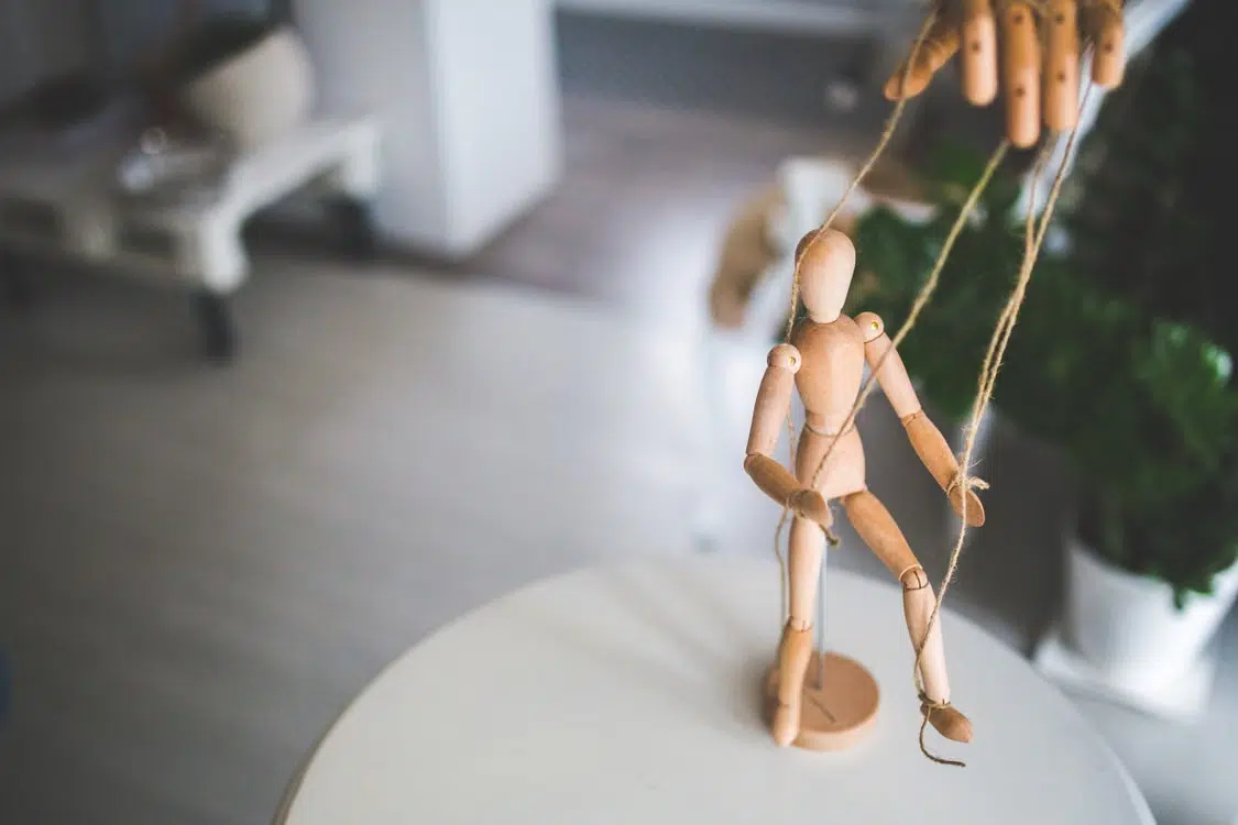 A wooden puppet with strings for control.