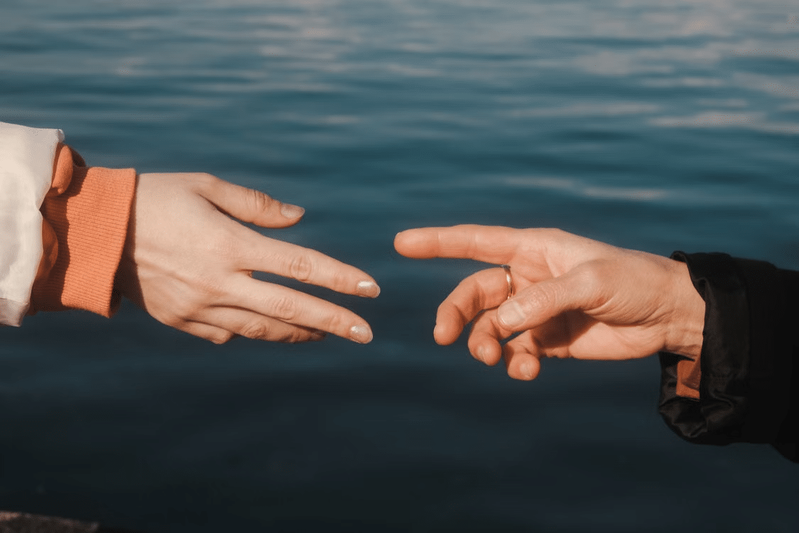 Two hands moving away from each other slowly.