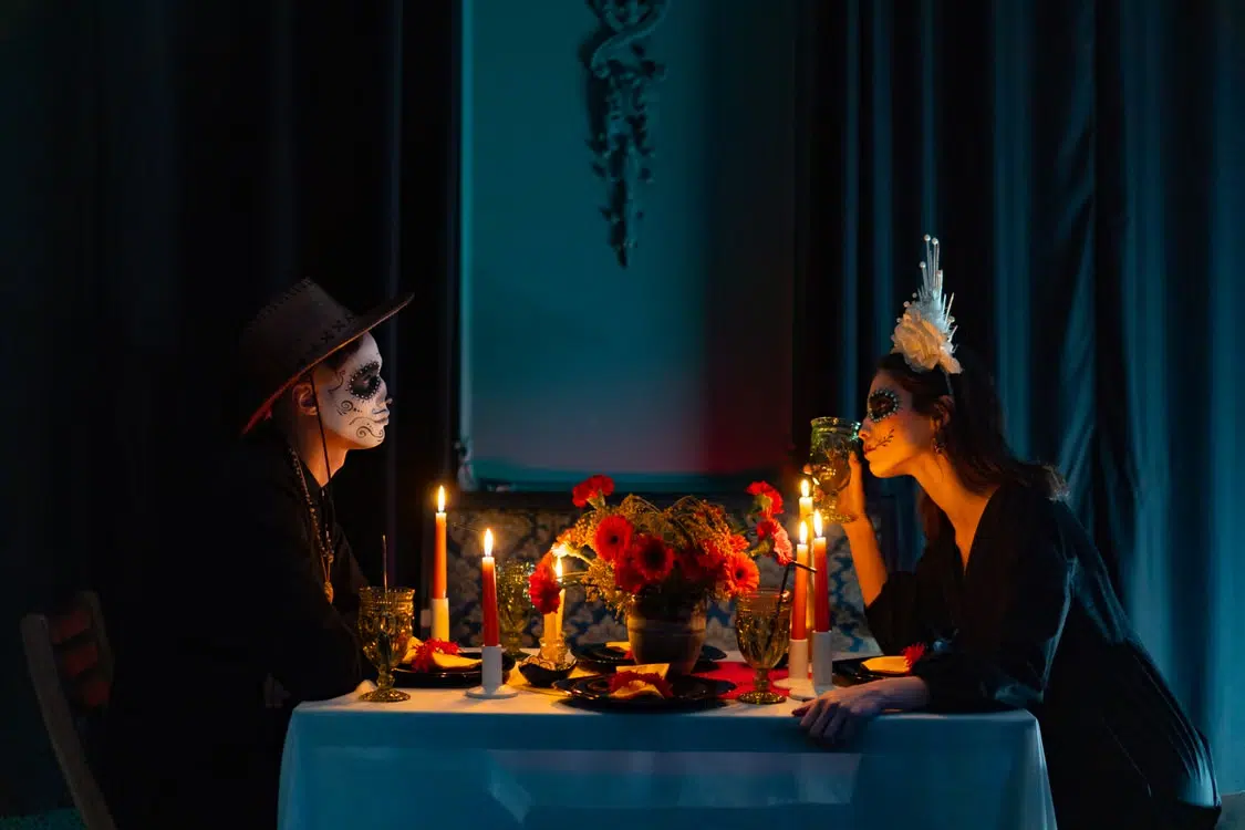 A couple having a Halloween themed candle light dinner.