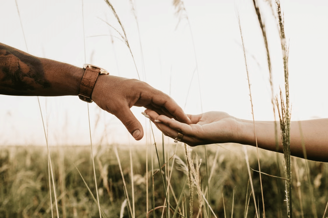 A man reaching for a woman's hand