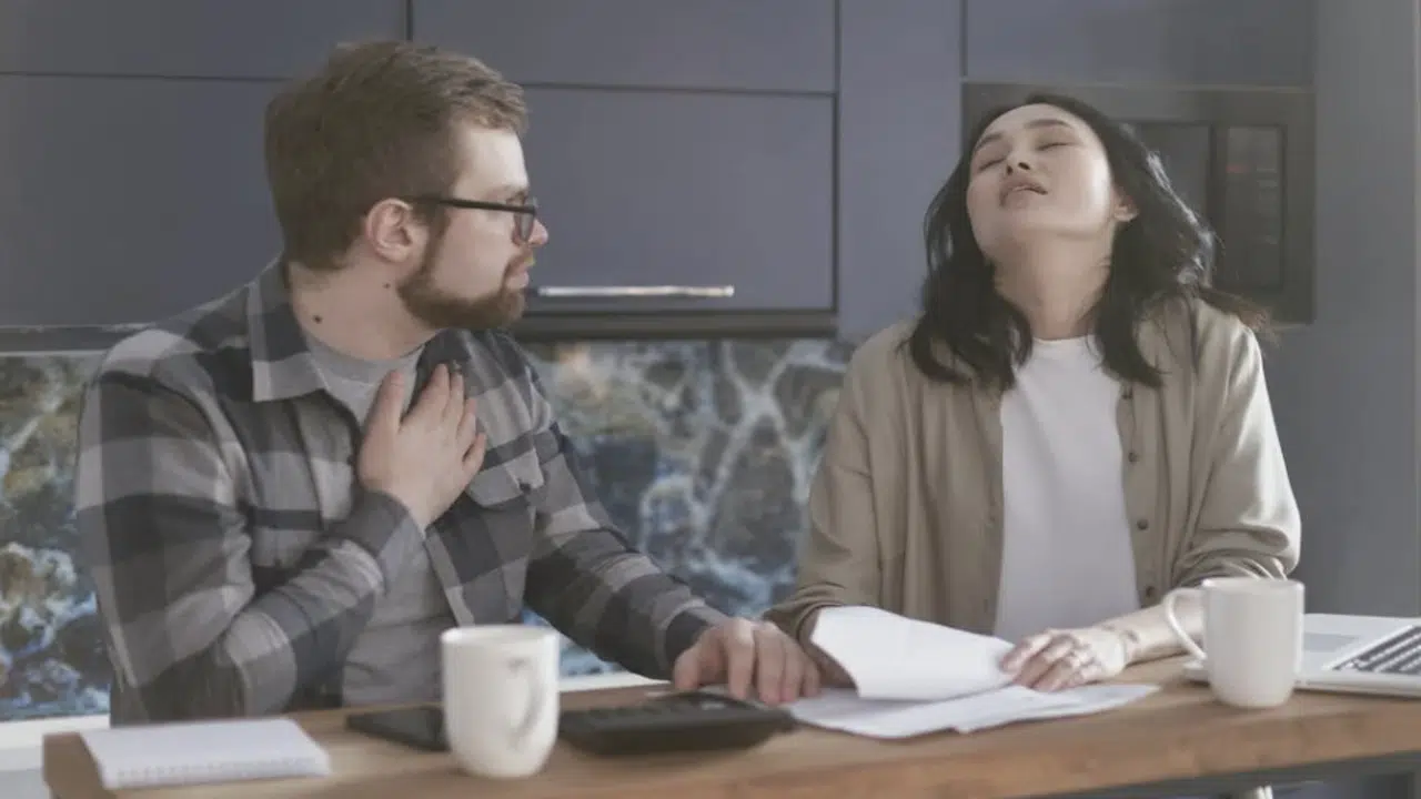 A seemingly calm man and a woman who seems frustrated arguing.
