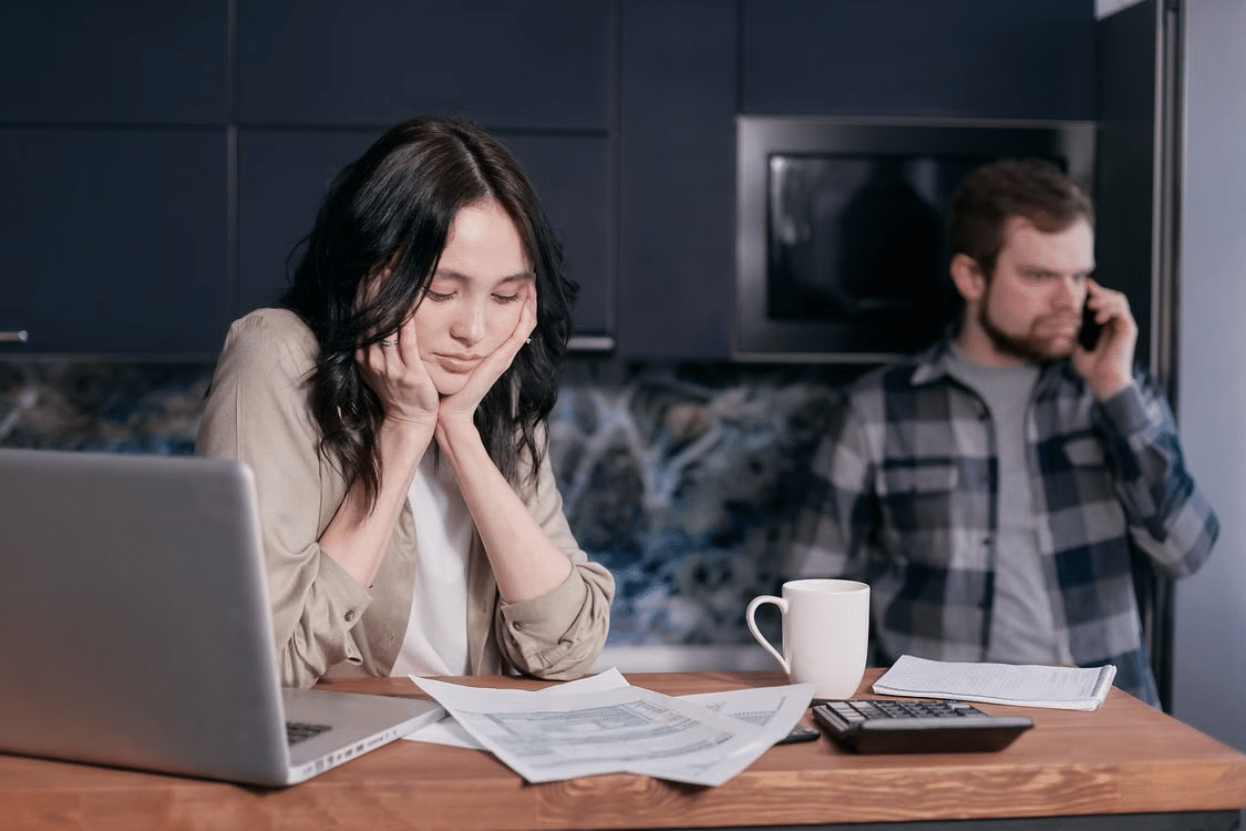 A couple looking at bills seeming distressed.