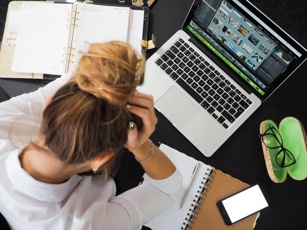 A woman overthinking and stressed out as she writes her thoughts in a diary.