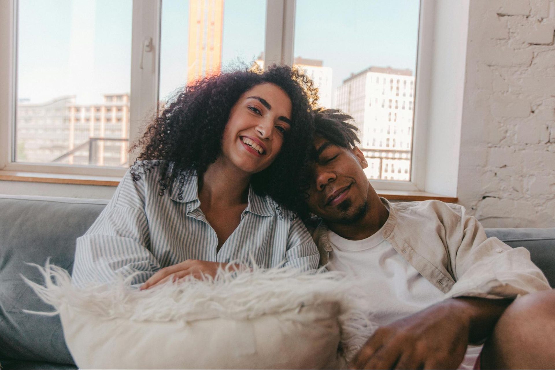 Woman leaning comfortably against a man while sitting together