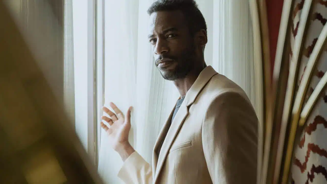 A man standing by a window looking outside.