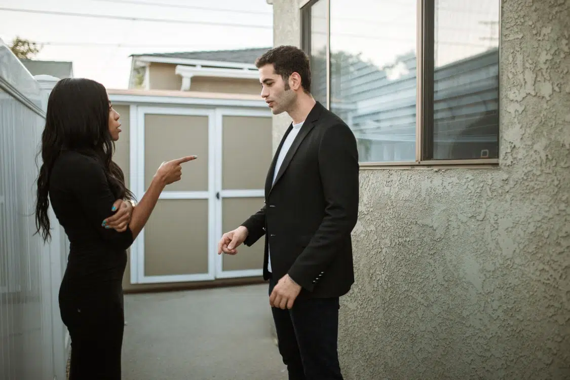 A woman pointing a finger at her partner blaming him.