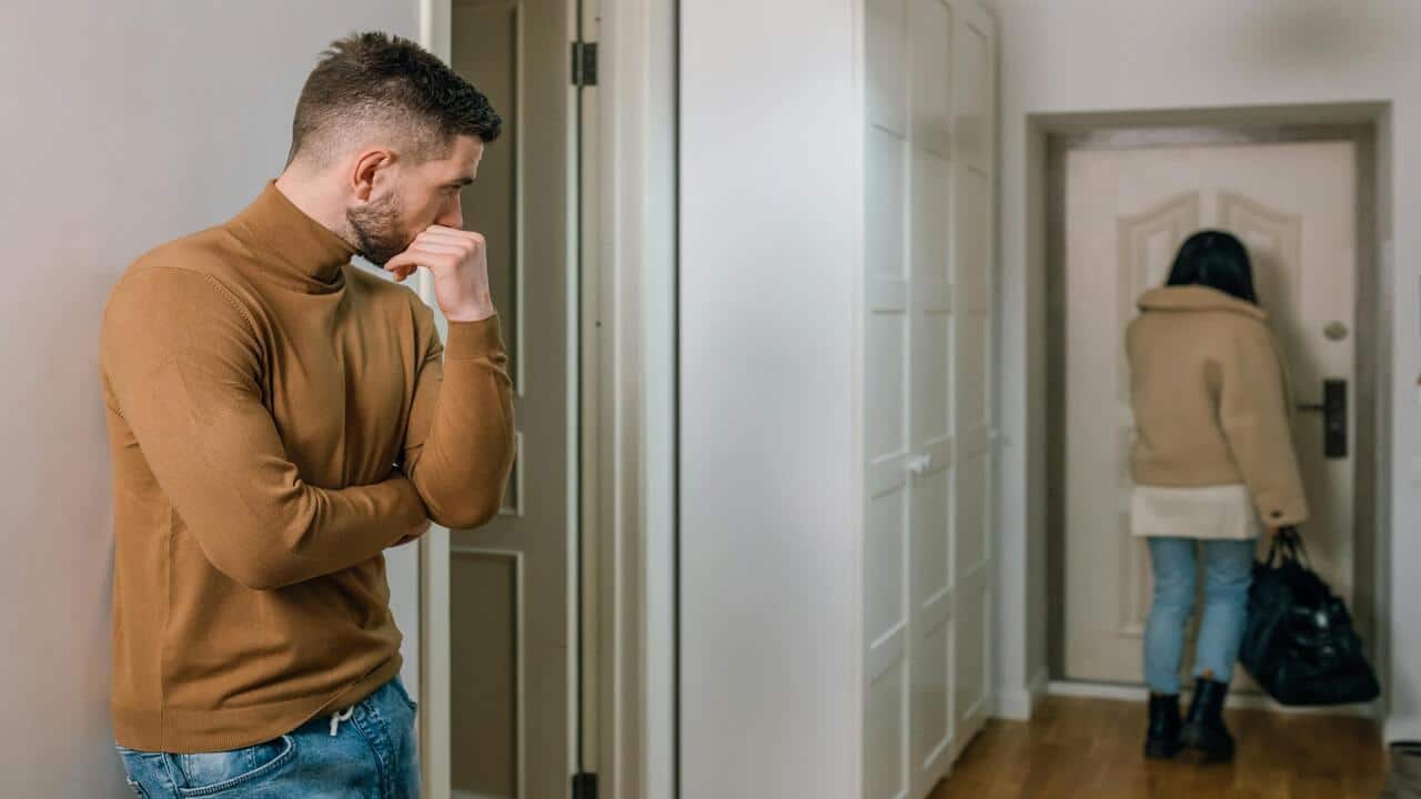 A man looking at a woman walking away