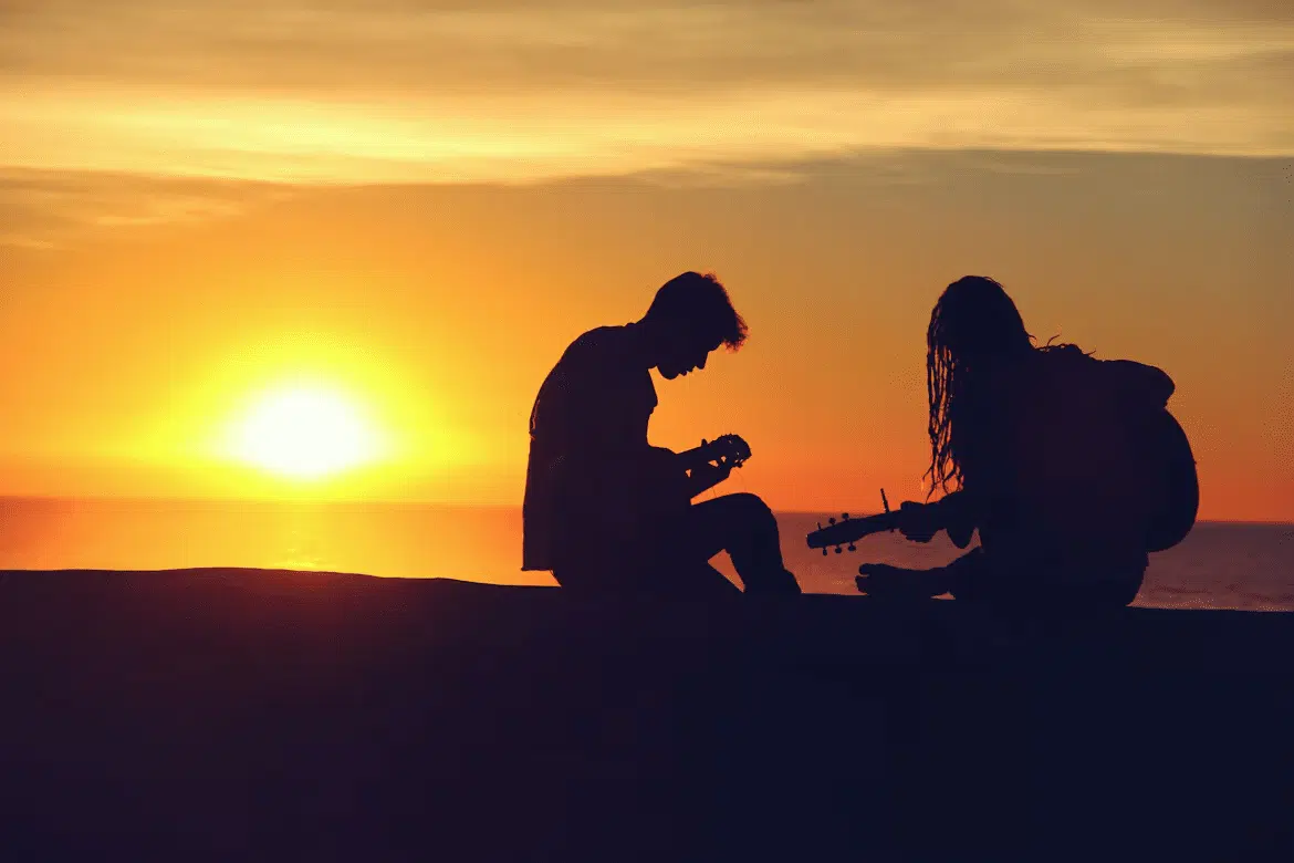 A silhouette of a couple with guitars.
