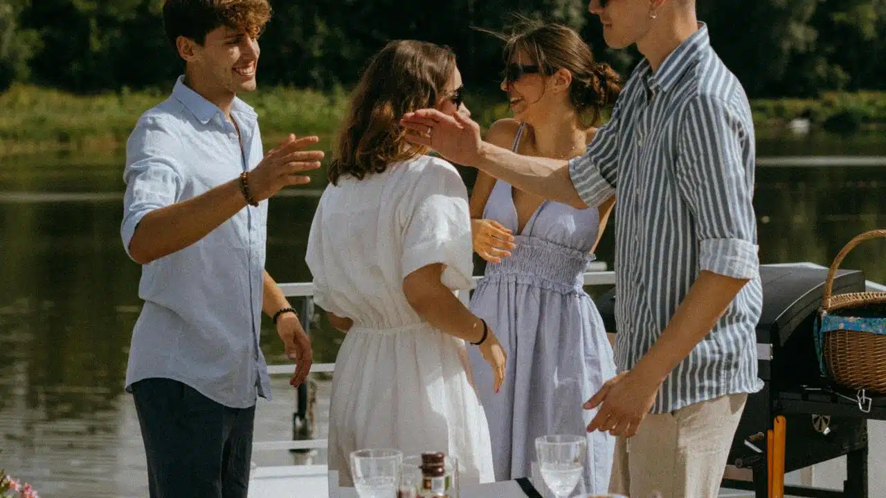A group of friends laughing together outdoors by the water.