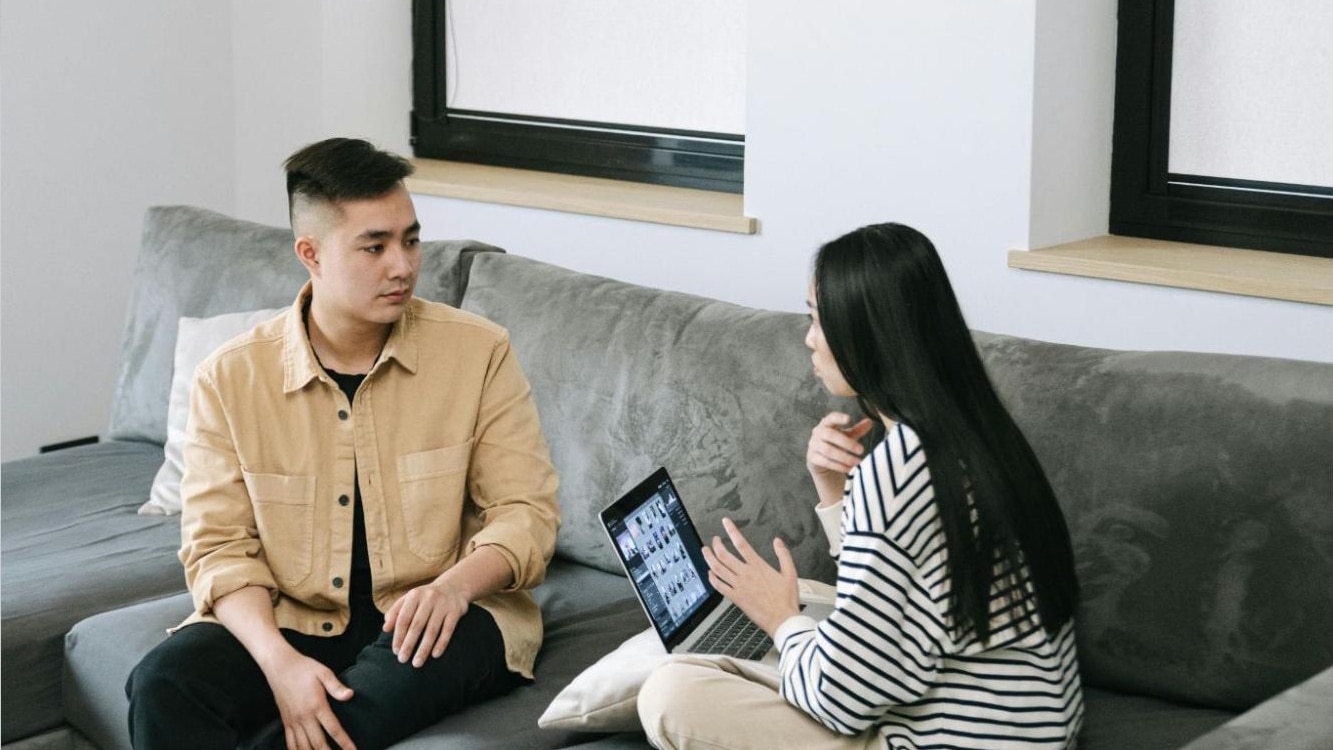 Woman sitting comfortably in casual clothes while talking freely with a man
