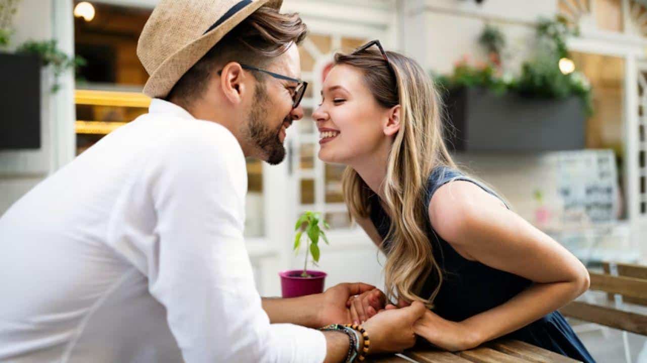 Couple smiling warmly while holding hands