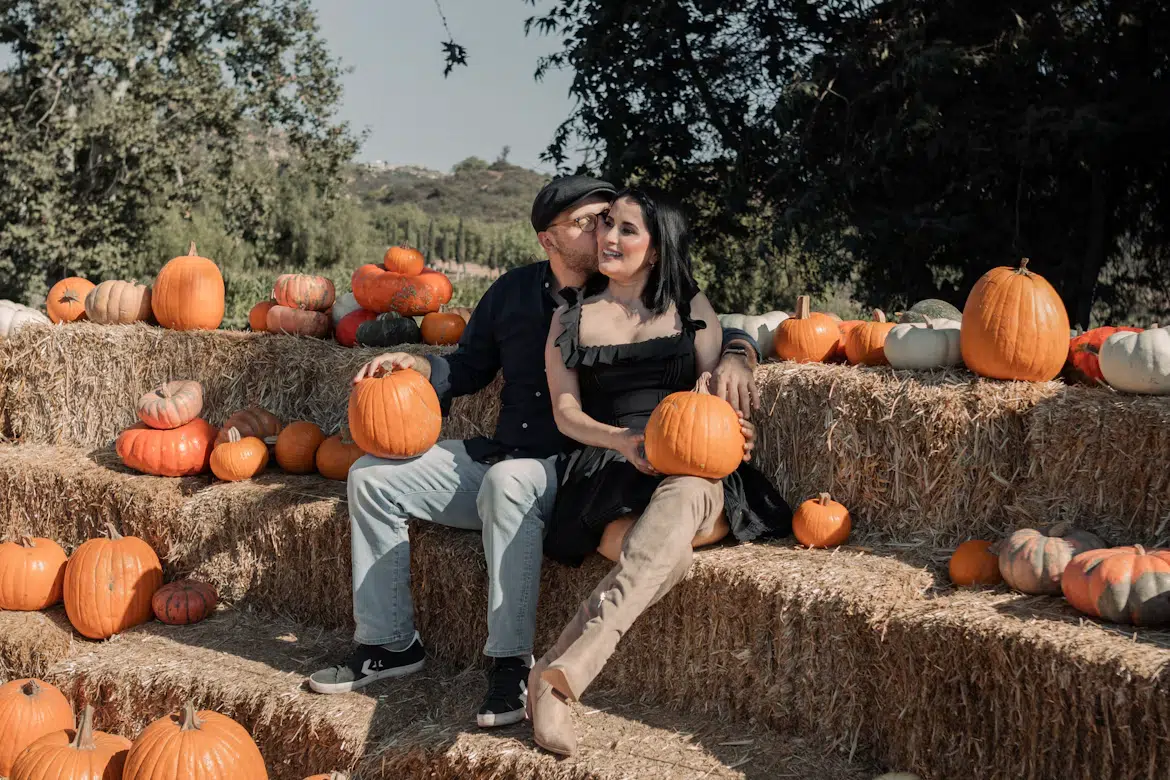 A romantic couple visiting a pumpkin patch.